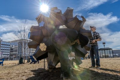 Rude Graves (at center) and Damon Brewer (at right) make final adjustments to Emergence. Photo by Trevor Finney for Virginia Tech.